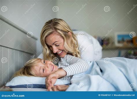 Mother and son having fun together in the bedroom .
